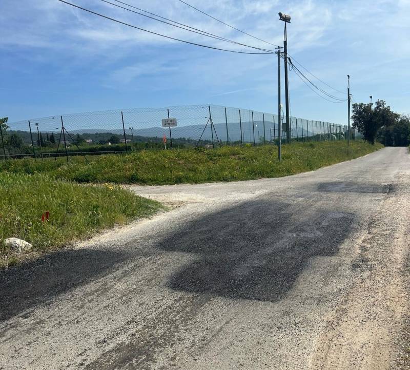 Patch en enrobé projeté pour réparation des nids de poule d'une route communale