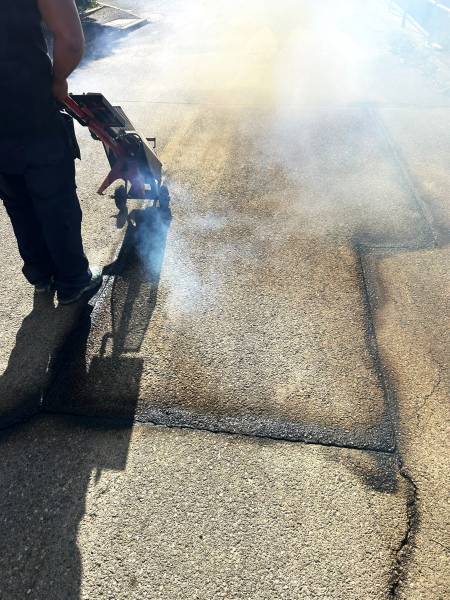 Nettoyage d'une fissure sur route en enrobé avec lance à air chaud compressé